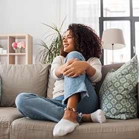 Woman grabs leg while sitting on the couch