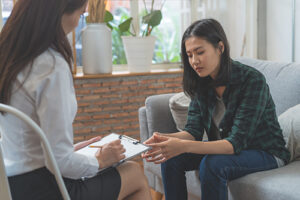 Teen sits on couch and listens to therapist suggest anxiety treatment