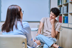 Teen talks to therapist about trauma during a PSTD treatment program