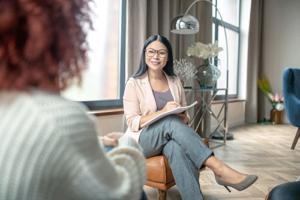 Woman sits in chair and talks to therapist about bipolar disorder treatment